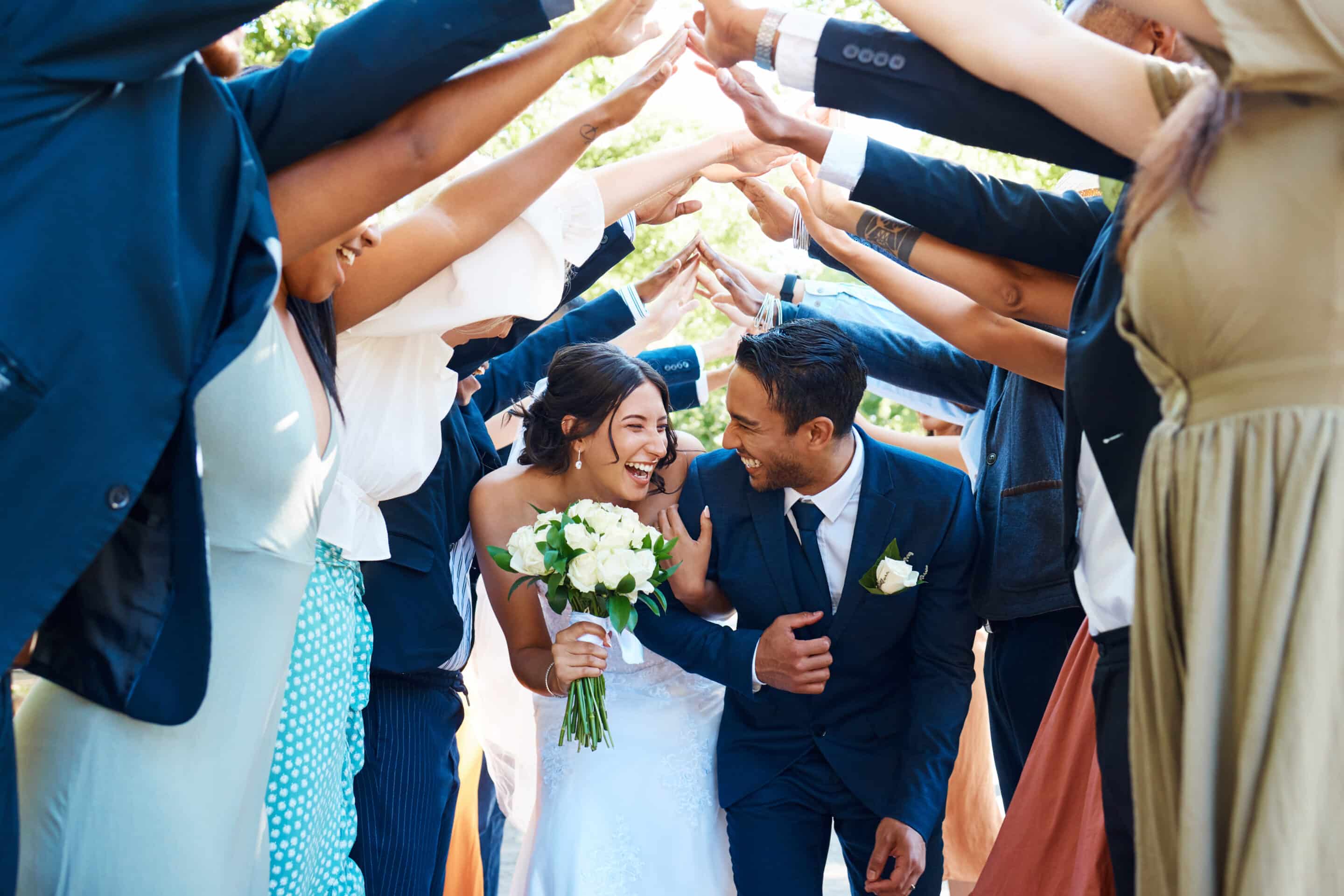 Wedding guests forming a tunnel with their hands as newlywed couple walk through it. Bride and groom entering their wedding reception, Heritage Center of Brooklyn Center.