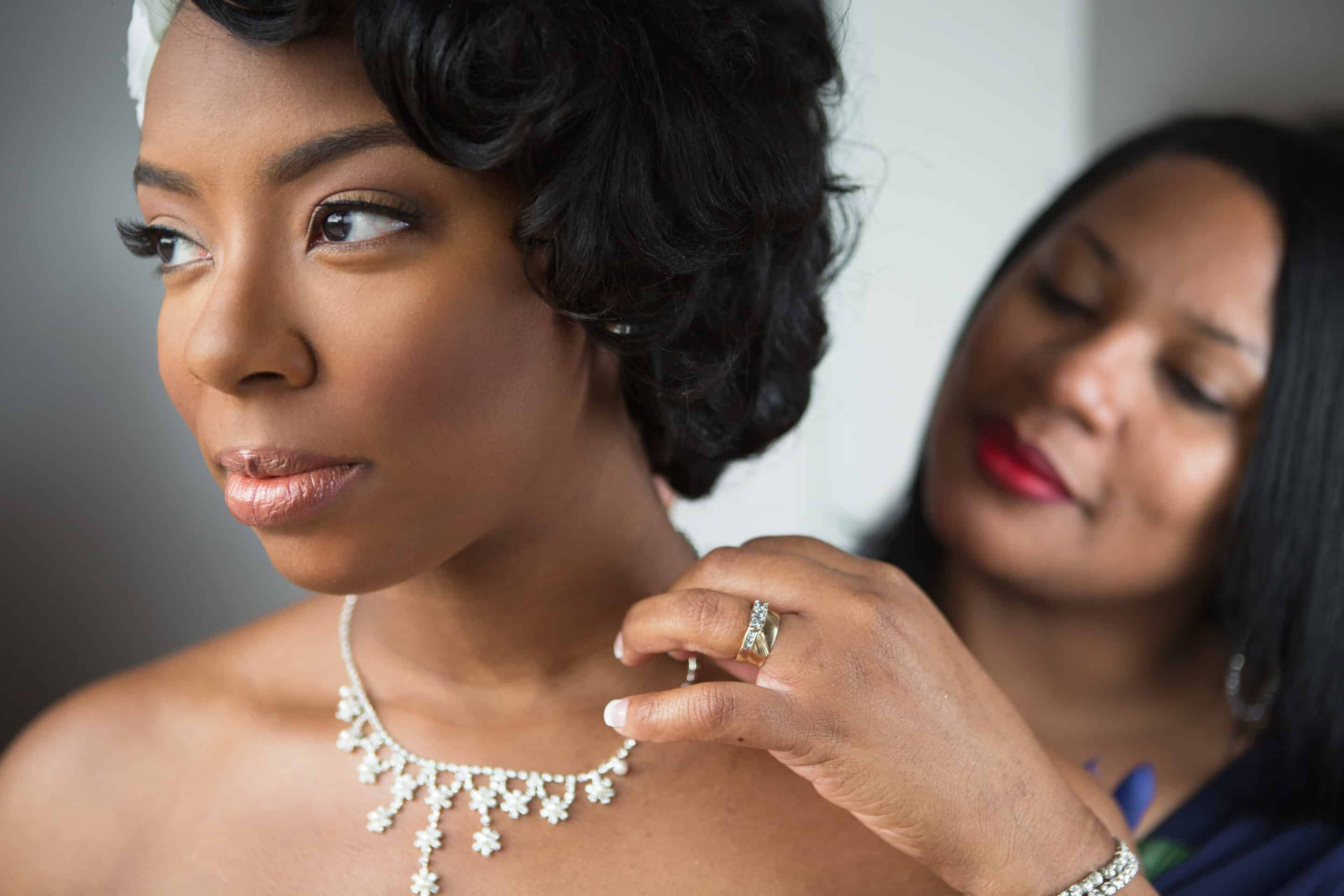 Mother helping her daughter get ready for her wedding at the Heritage Center of Brooklyn Center.