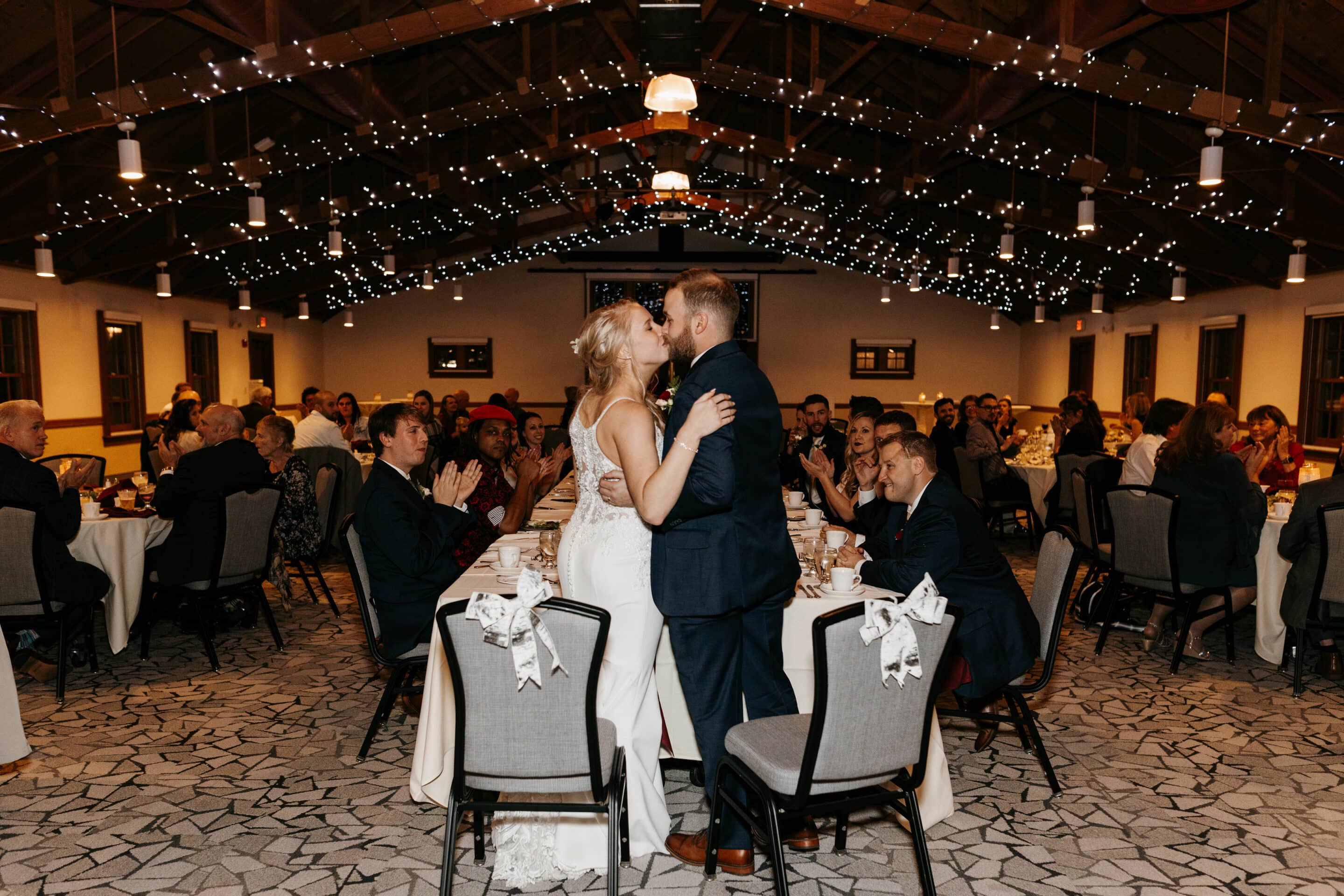 Jacklyn and Adam kissing at a wedding reception